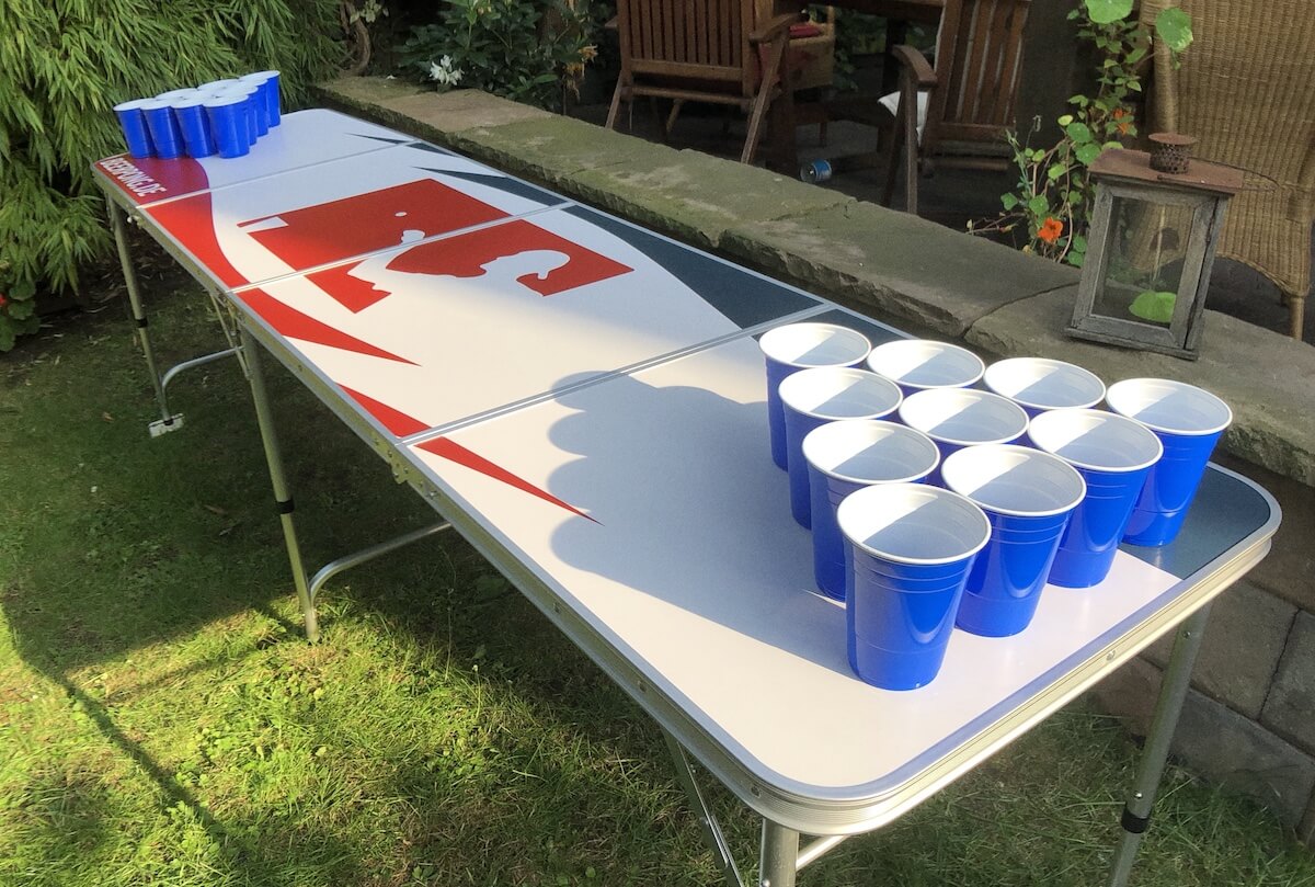 Blaue Solo Cups stehen auf einem Bier Pong Tisch im Garten