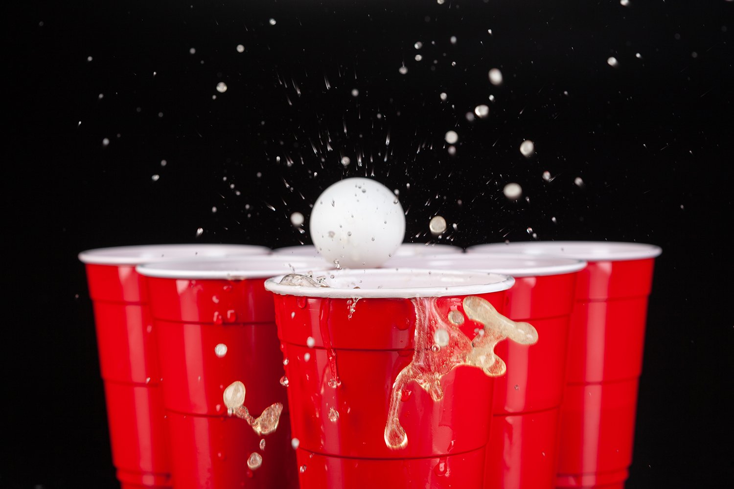 Beerpong Ball landet platschend in Beer Pong Becher