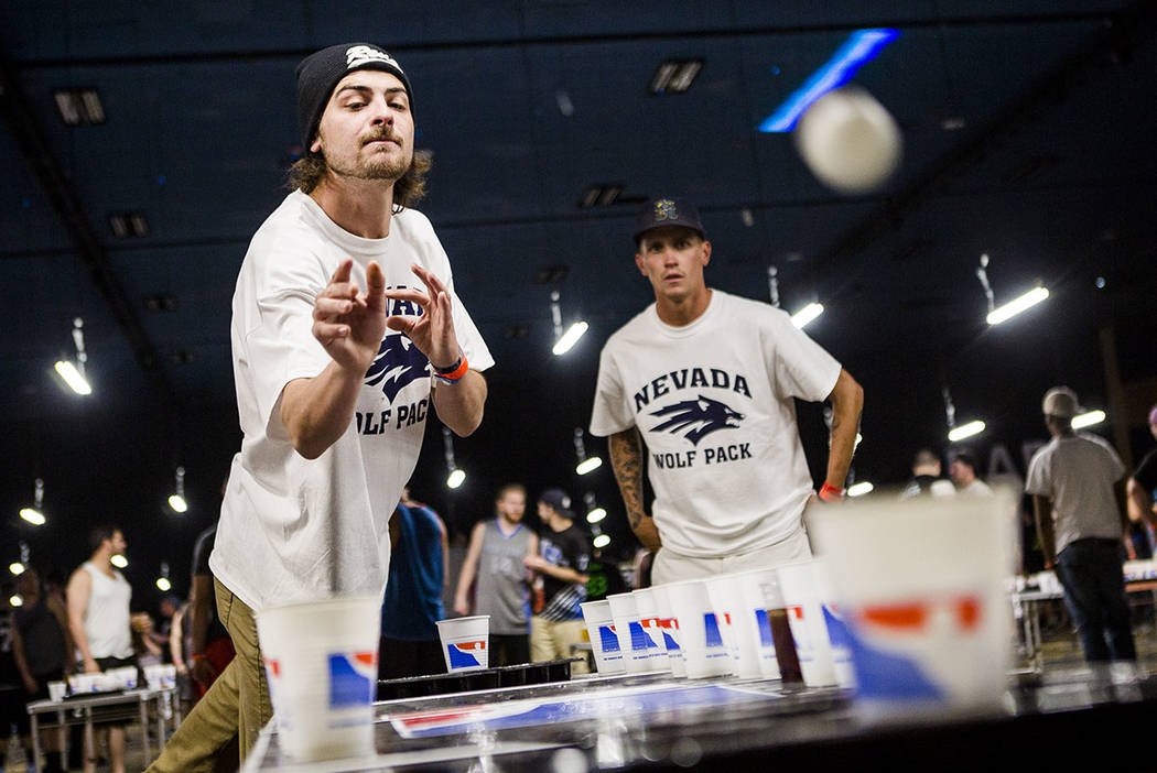 Ehrgeztiger Mann wirft Ball auf Beerpong Turnier