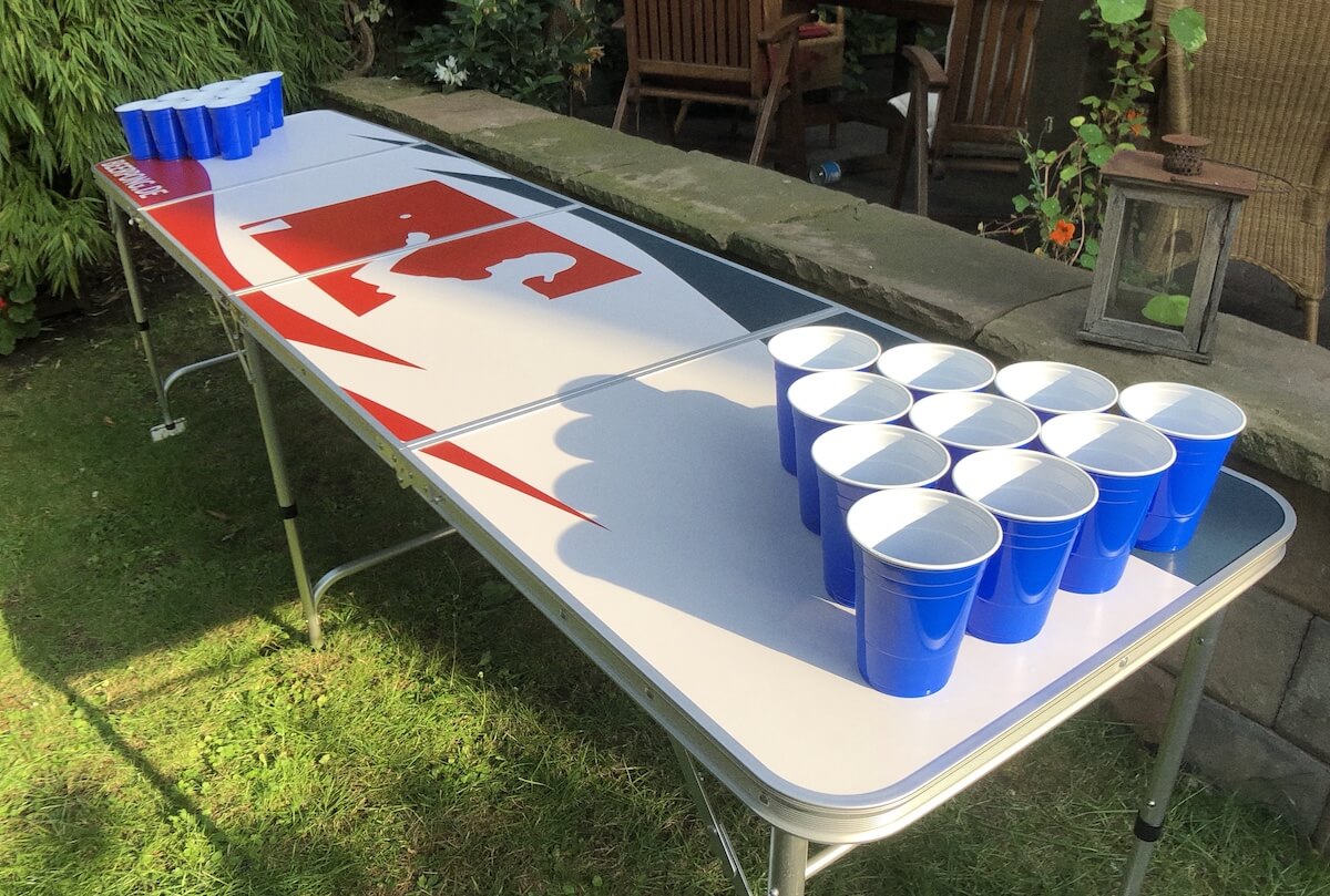 Blaue Solo Cups stehen auf einem Bier Pong Tisch im Garten
